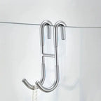 Rust Resistant Multifunctional Shower Door Hook displayed on a sleek bathroom wall, ideal for towels and loofahs.